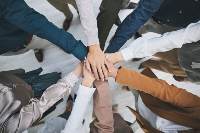Teamwork and collaboration: hands joined in a circle, symbolizing unity and partnership.